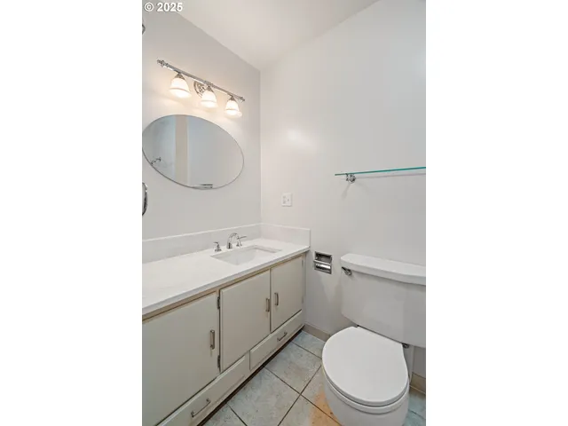 a bathroom with a toilet a sink and mirror