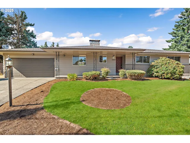 a view of a backyard with table and chairs potted plants and large tree