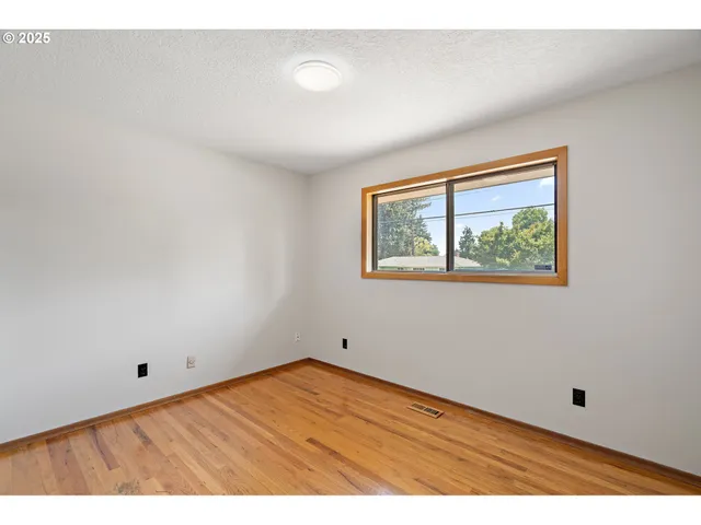 a view of empty room with wooden floor