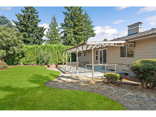 a view of a house with backyard and sitting area
