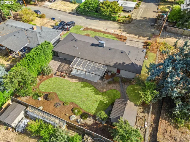 an aerial view of a house with a garden and lake view