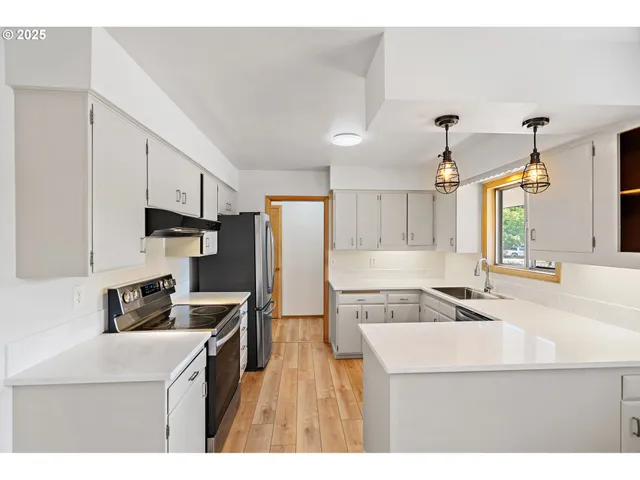 a kitchen with kitchen island a sink stove and refrigerator
