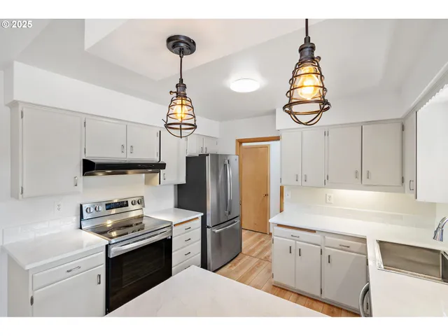 a kitchen with granite countertop a sink stainless steel appliances and cabinets