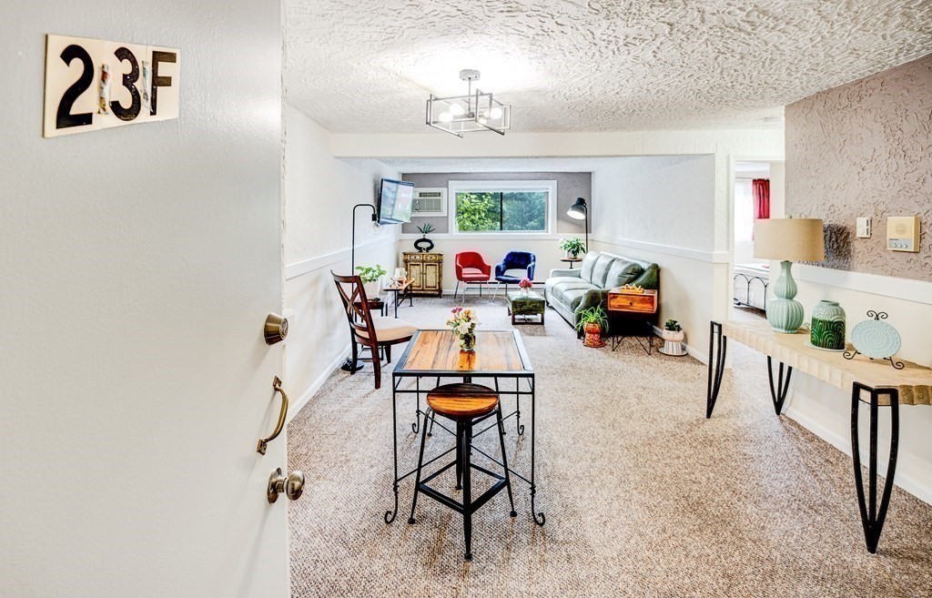 294 Codman Hill Road, Unit 23F Boxborough, MA 01719 - Photo 1 of 22 a living room with furniture and a chandelier