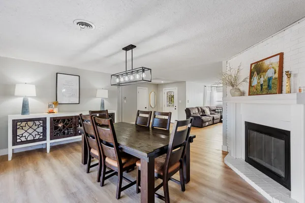 a view of a dining room with furniture a chandelier and wooden floor