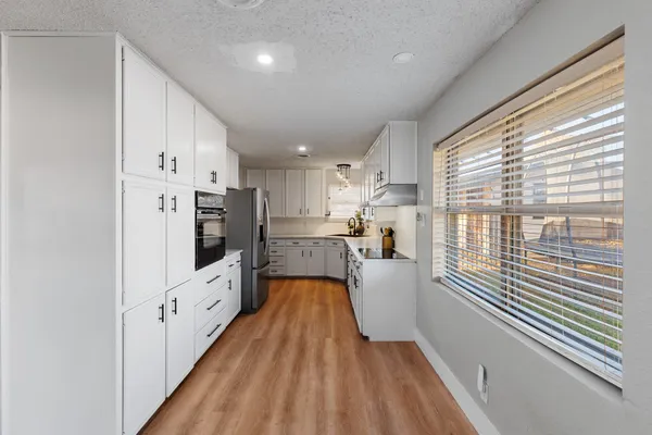 a kitchen with cabinets and wooden floor