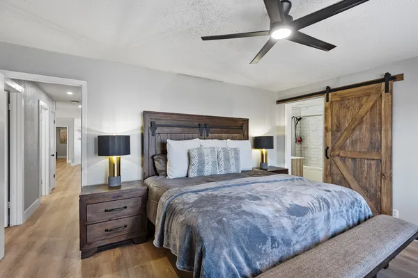 a bedroom with a large bed and a chandelier