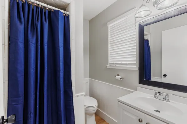 a bathroom with a sink a toilet a mirror and shower