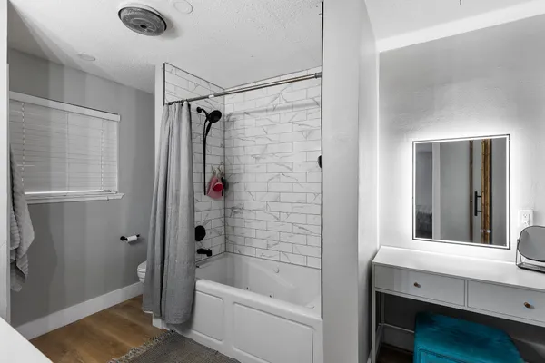 a bathroom with a tub shower vanity and a sink