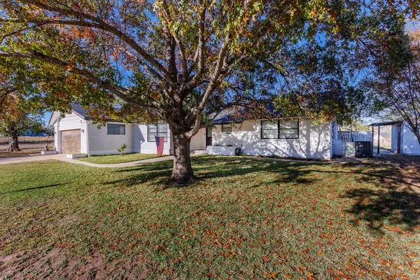 a view of a house with a yard garage and tree