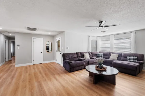 a living room with furniture and a wooden floor