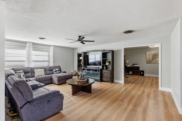 a living room with furniture and a wooden floor