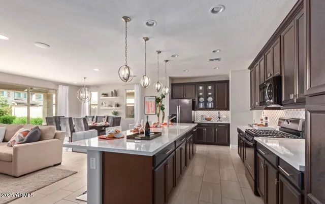 a large kitchen with stainless steel appliances kitchen island granite countertop a lot of cabinets a stove a sink and dishwasher