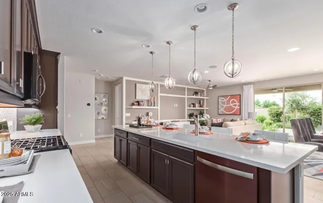 a kitchen with stainless steel appliances granite countertop a sink a stove and a wooden floors