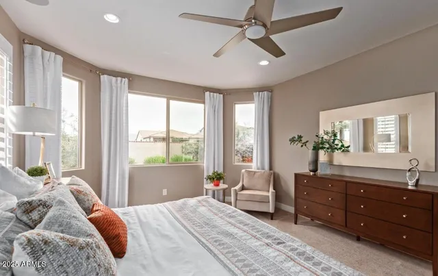 a bedroom with a bed and large windows