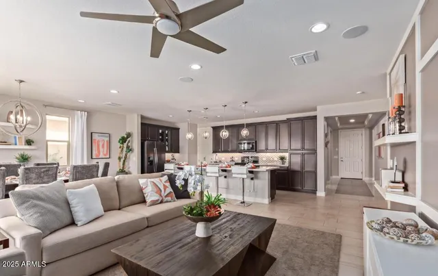 a living room with furniture kitchen view and a large window