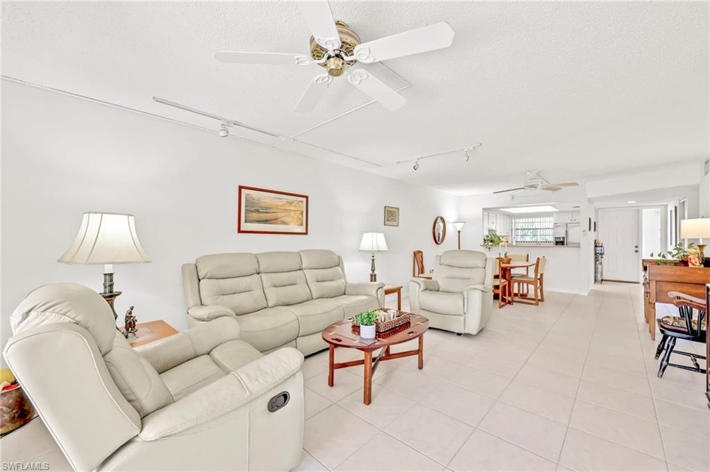 151 Cypress Way East, Unit C103 Naples, FL 34110 - Photo 13 of 29 a living room with furniture and a chandelier