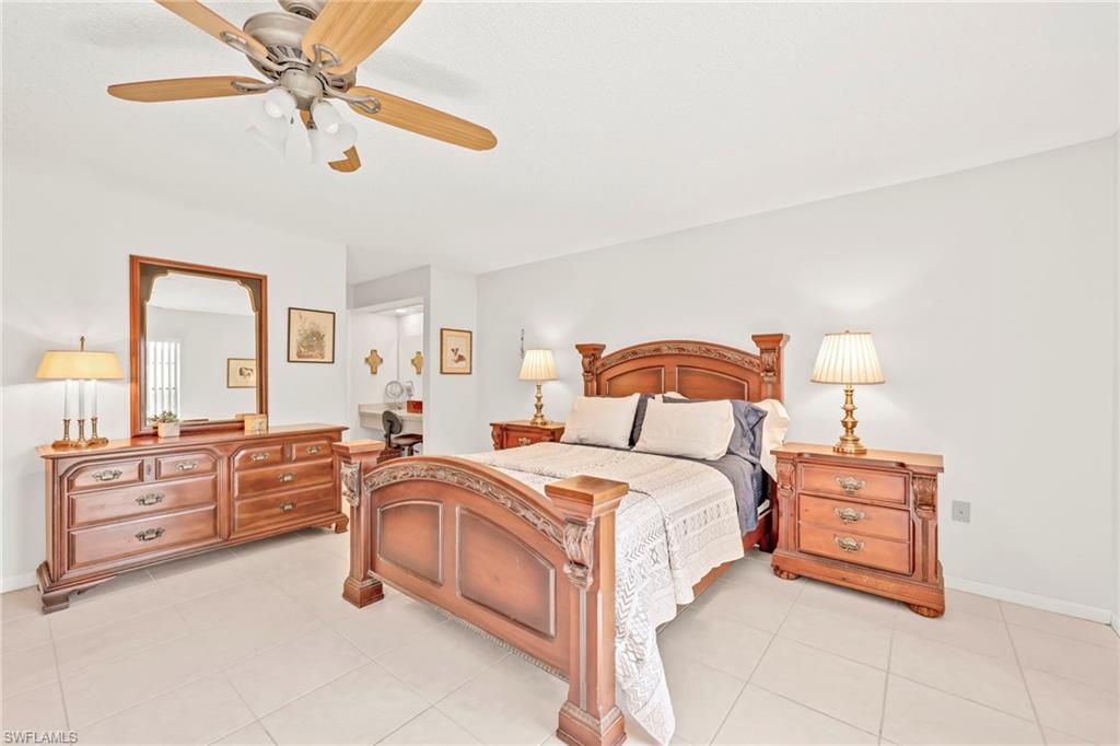 151 Cypress Way East, Unit C103 Naples, FL 34110 - Photo 16 of 29 a bedroom with a bed and ceiling fan
