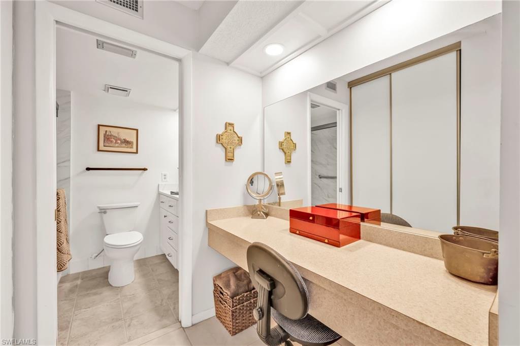 151 Cypress Way East, Unit C103 Naples, FL 34110 - Photo 17 of 29 a bathroom with a sink and a mirror