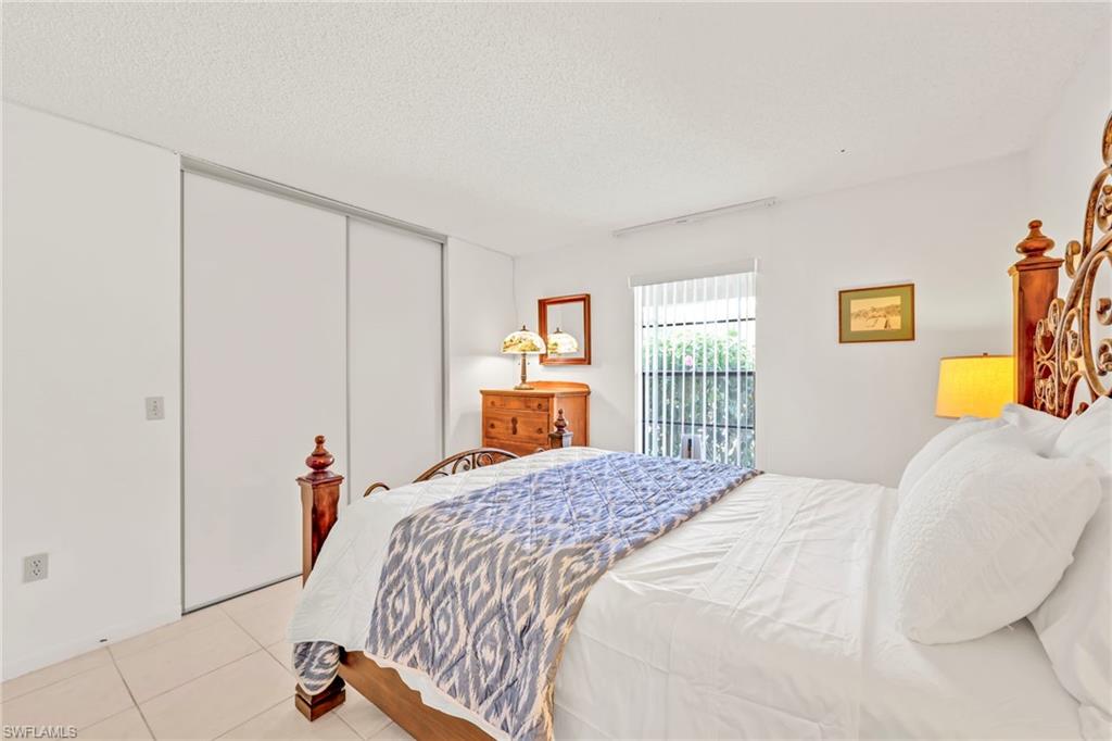 151 Cypress Way East, Unit C103 Naples, FL 34110 - Photo 20 of 29 a bedroom with a bed and a window