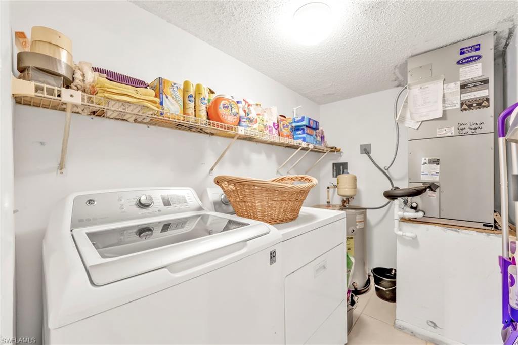 151 Cypress Way East, Unit C103 Naples, FL 34110 - Photo 23 of 29 a utility room with dryer and washer