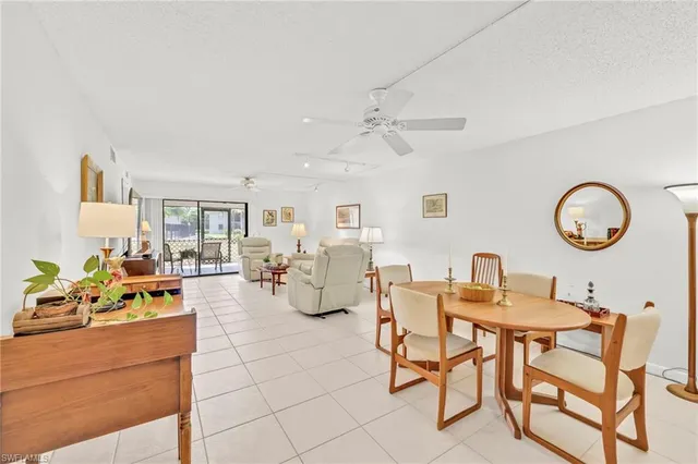 a view of a dining room and livingroom with furniture wooden floor a rug and a chandelier