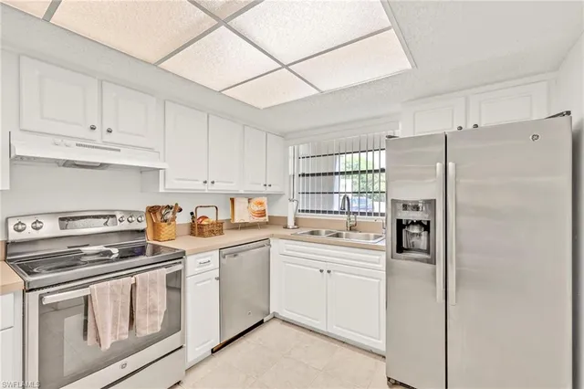 a kitchen with white cabinets and white appliances