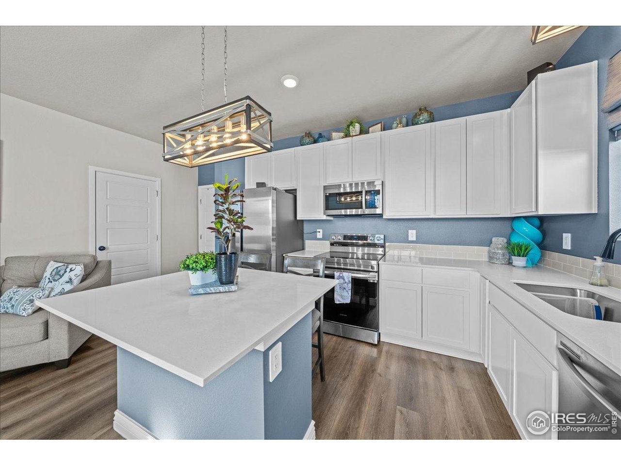 341 Cardinal Street Johnstown, CO 80534 - Photo 6 of 21 a kitchen with stainless steel appliances a white stove top oven a sink a counter space and cabinets