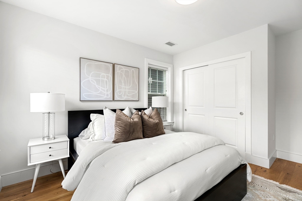 30 Polk Street, Unit 208 Boston, MA 02129 - Photo 10 of 24 a bedroom with a bed and a lamp