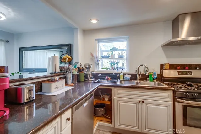 a kitchen with stainless steel appliances granite countertop a sink stove and cabinets