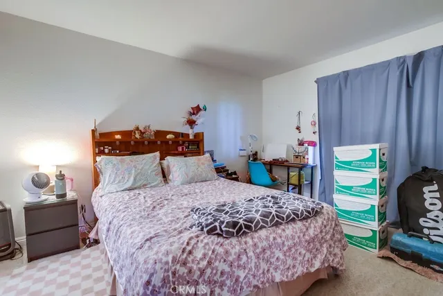 a bedroom with a bed and a lamp on dresser