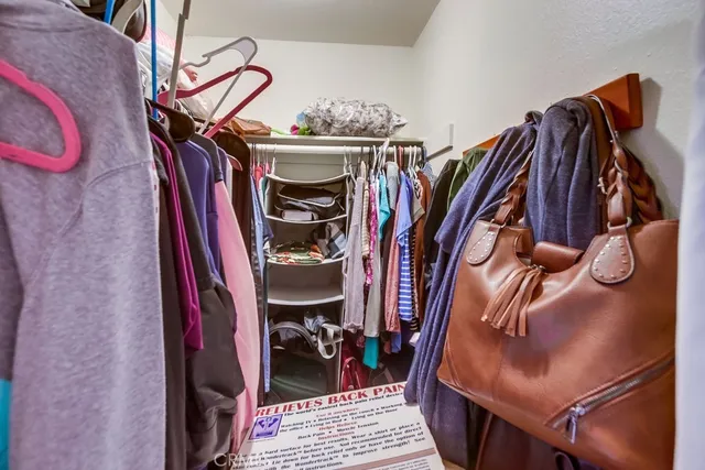 a view of walk in closet with clothes and shoes
