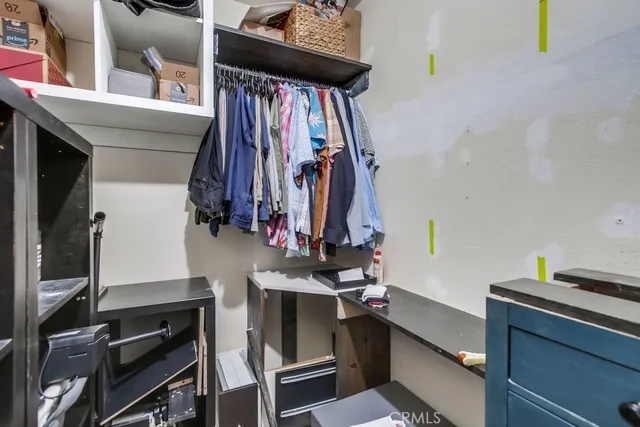 a view of walk in closet with clothes and shoes