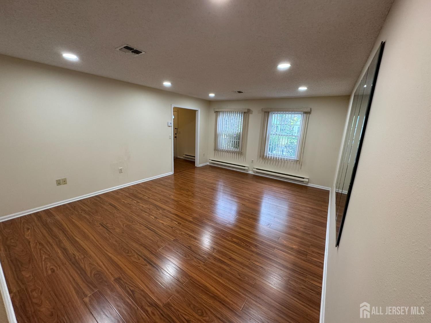 723 Mt Vernon Road, Unit A Monroe Township, NJ 08831 - Photo 3 of 19 an empty room with wooden floor and windows