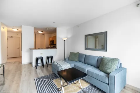 a living room with furniture and a dining table with wooden floor