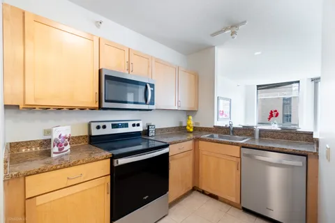 a kitchen with stainless steel appliances granite countertop a sink stove and microwave