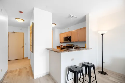 a kitchen with stainless steel appliances a stove top oven a sink a refrigerator and a microwave