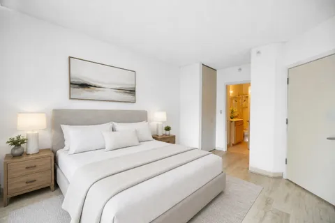 a bedroom with a bed and a painting on the wall