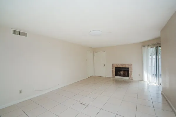 an empty room with fireplace and windows