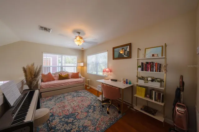 a living room with furniture a rug and a bookshelf