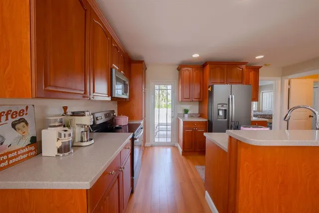 a kitchen with stainless steel appliances granite countertop a sink stove and refrigerator