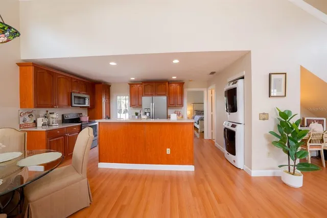 a living room with stainless steel appliances kitchen island granite countertop furniture wooden floor and a view of kitchen