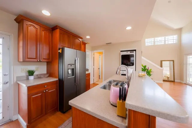 a kitchen with stainless steel appliances wooden floor dining table and chairs