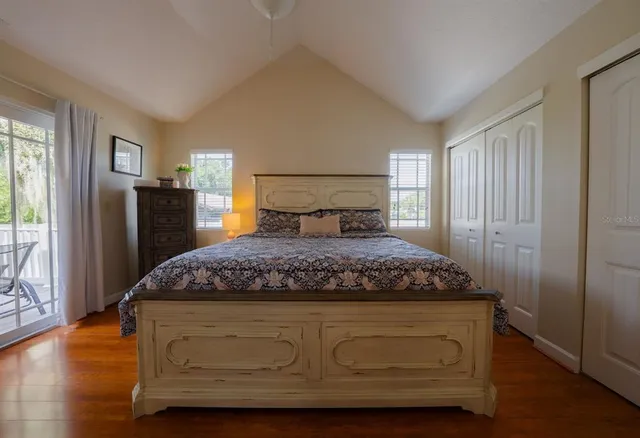 a bedroom with a bed and wooden floor