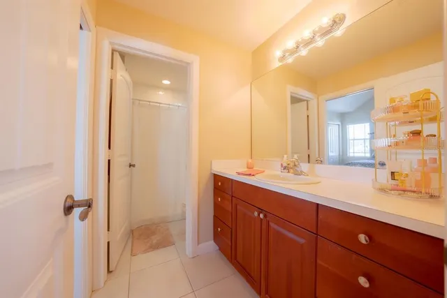 a spacious bathroom with a double vanity sink and mirror with shower