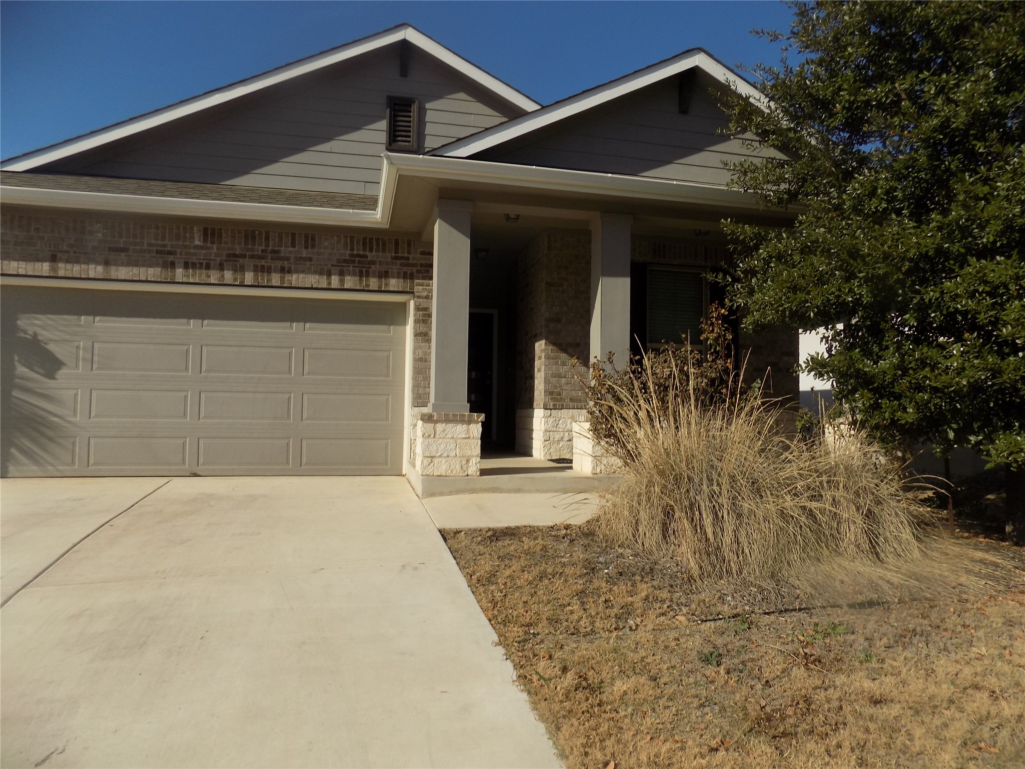 This charming home offers curb appeal with its inviting exterior and lush greenery.