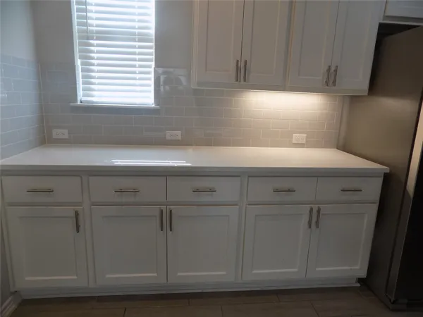 a kitchen with a white cabinets and a window