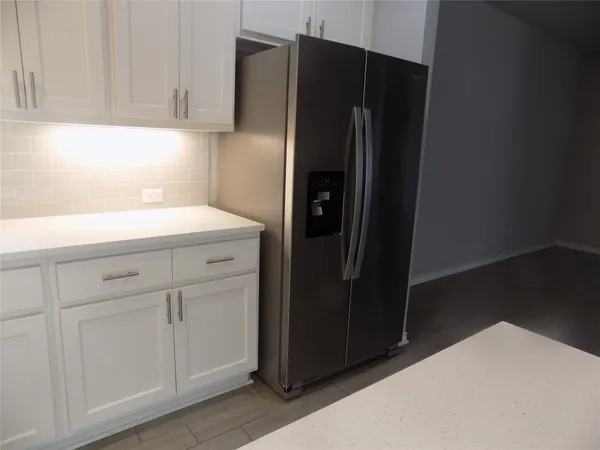 a kitchen with a refrigerator and cabinets