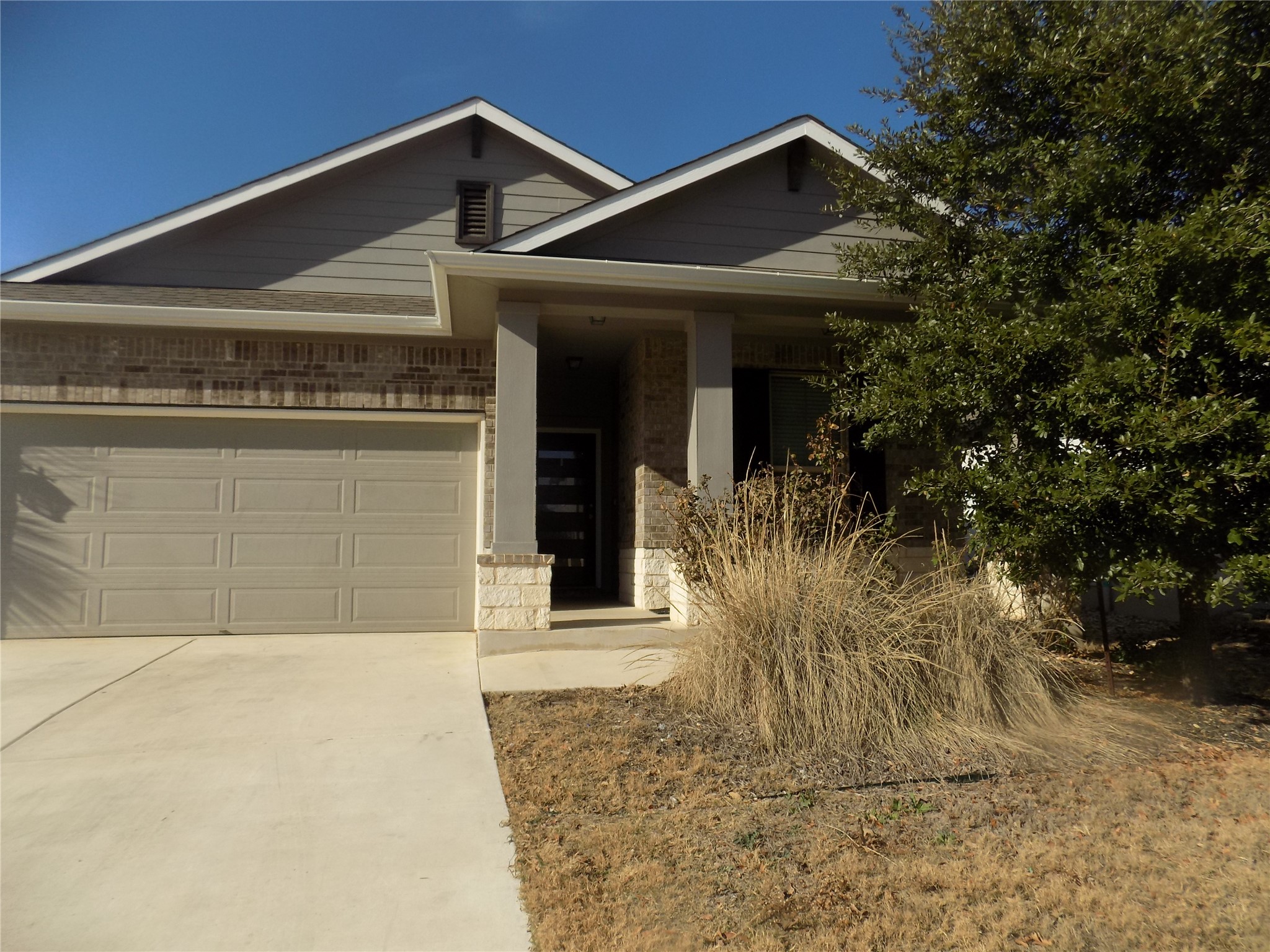 1133 Capra Lane Leander, TX 78641 - Photo 2 of 25 The home features a classic brick and siding exterior with an attached garage and inviting entry.