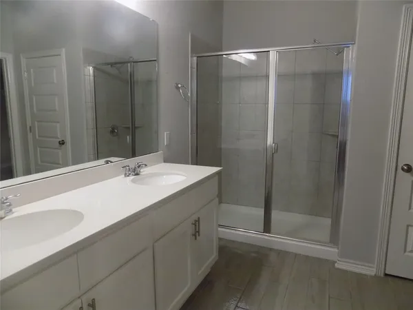 a bathroom with a shower sink vanity and mirror